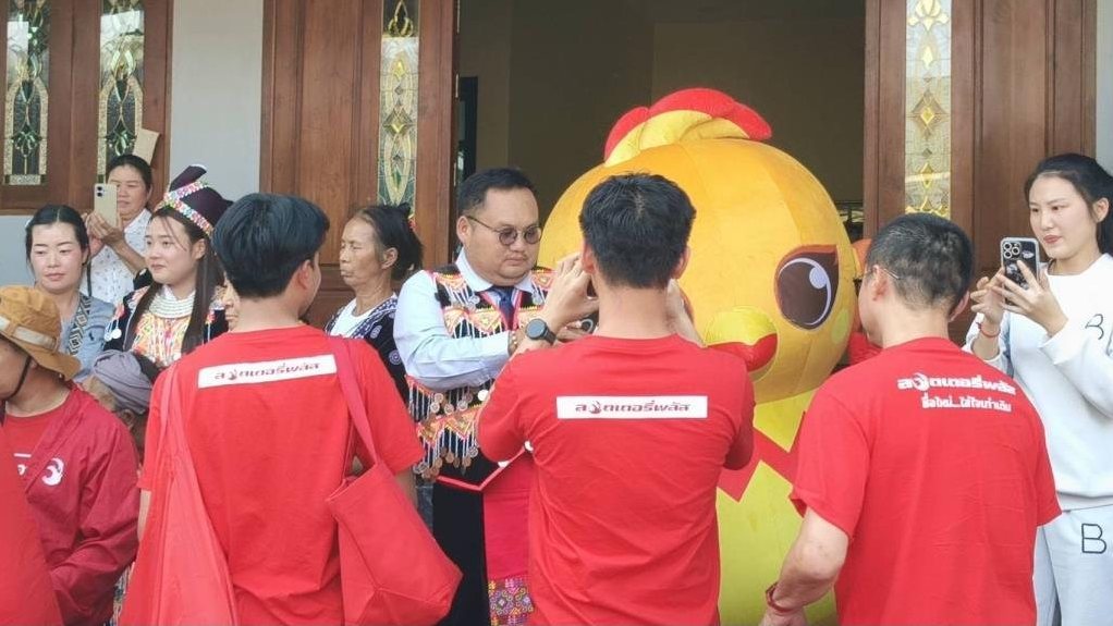 Thai government lottery winner in traditional dress greets the digital lottery platform team outside his Chiang Rai home during the 60 million baht prize handover