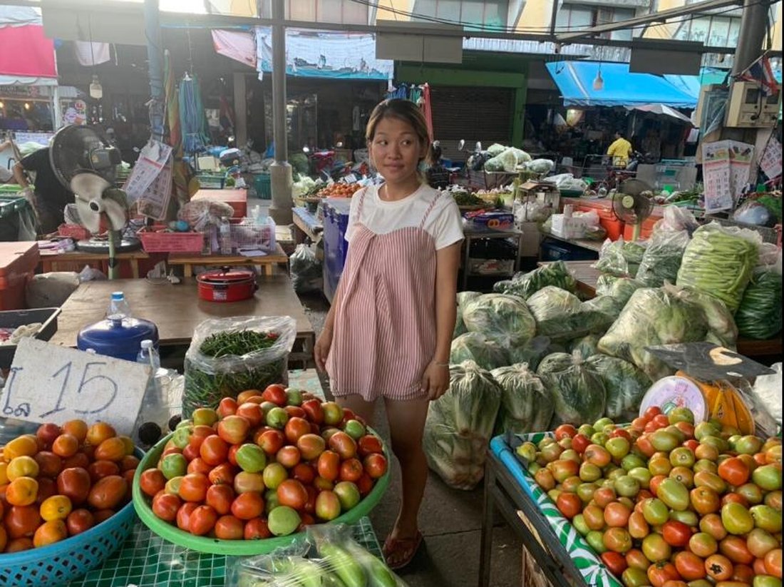 Thai lottery winner Inthira Saisun standing at her fresh vegetable stall in the Kamphaeng Phet market where she sells tomatoes and greens