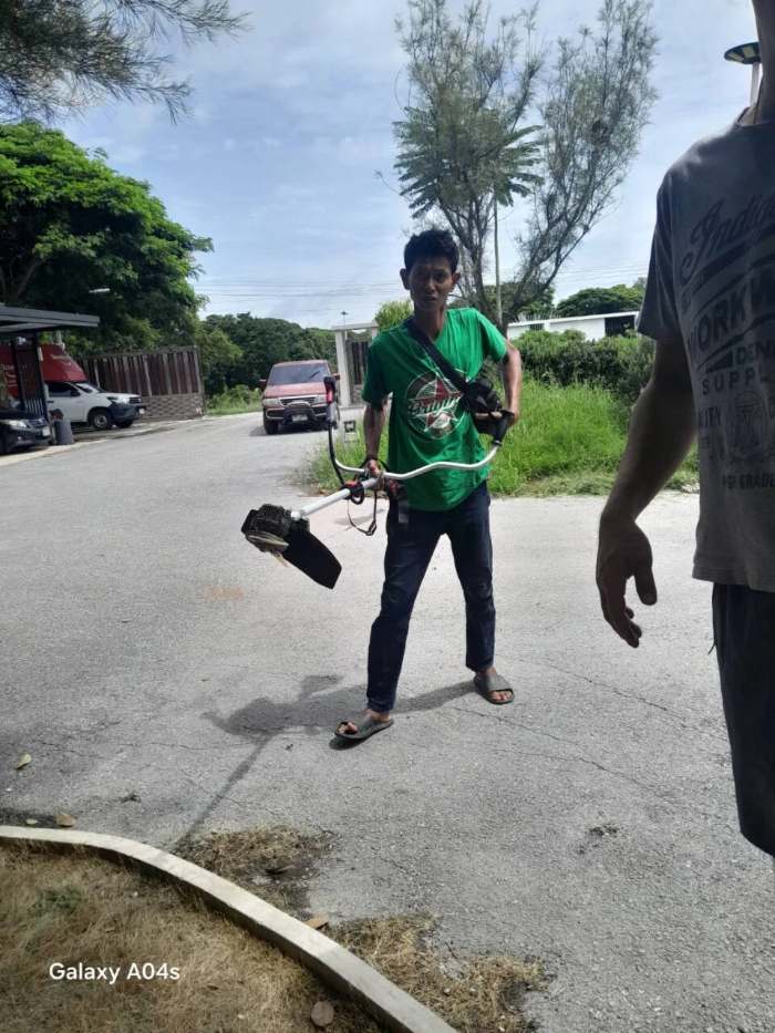 Thai government lottery winner Sompong Phusakul holding the brush cutter he was using on the morning of the 16 September 2026 Thai lottery first prize draw in Lopburi
