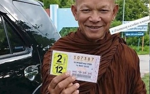Thai lottery winner Phra Khru Amnuay, a monk in Khon Kaen, holding the winning ticket 107387