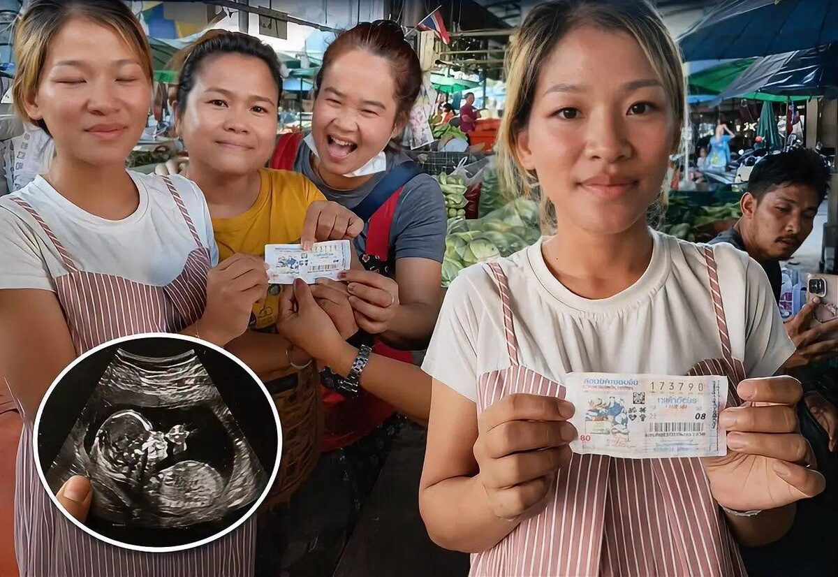 Thai lottery first prize winner Inthira Saisun holding her winning ticket number 173770 with fellow vegetable vendors at the market